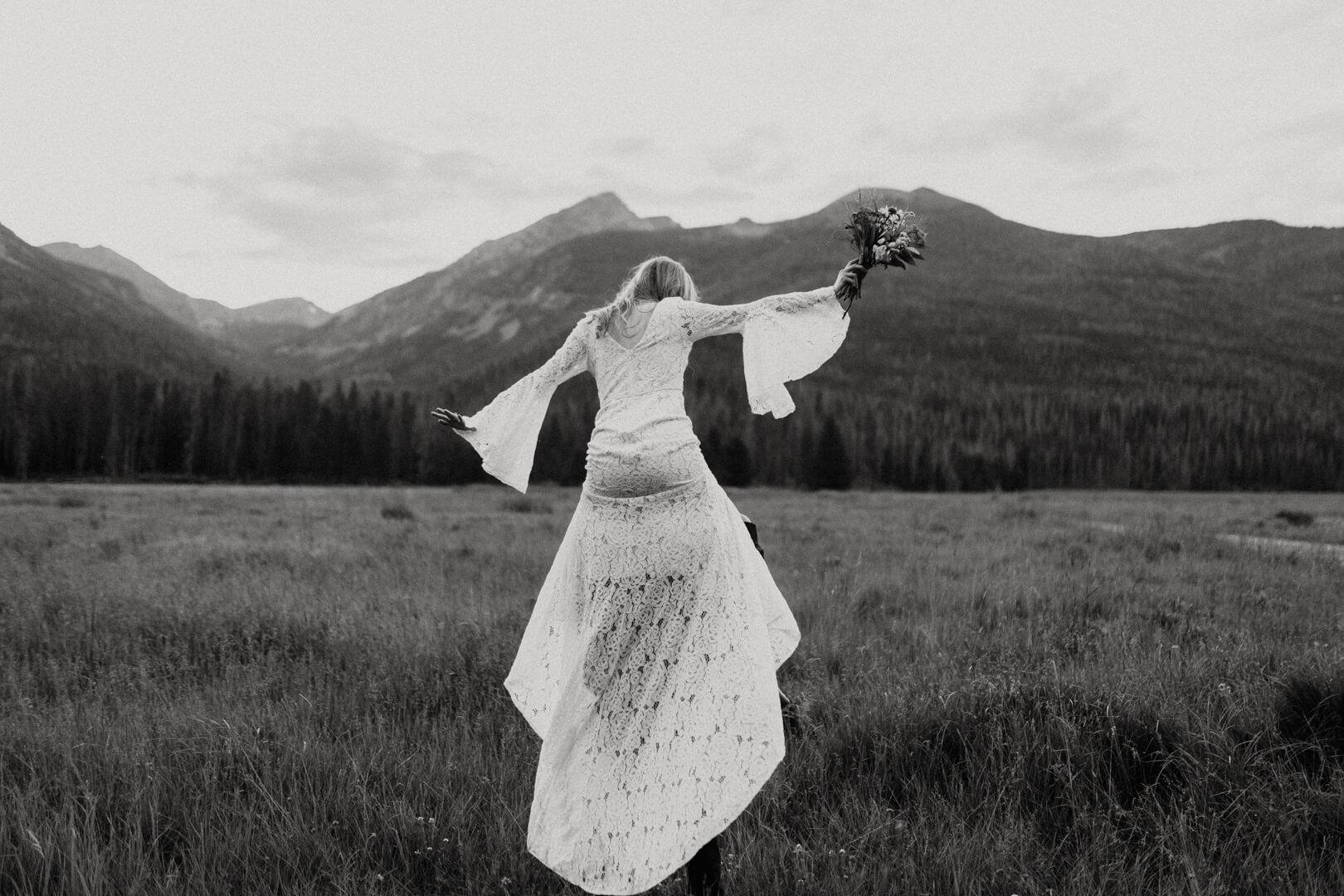 bride riding around on her husband's shoulders during their RMNP elopement.