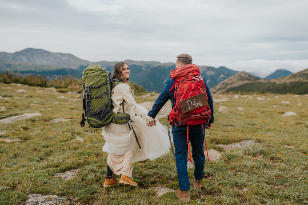 adventurous couple hiking through the tundra with boots and backpacks during their Rocky Mountain National Park elopement.