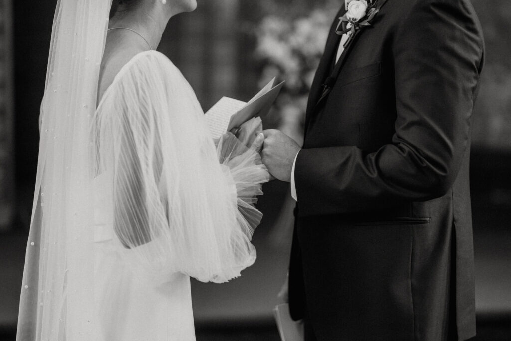 bride holding her grooms hands as she says her vows