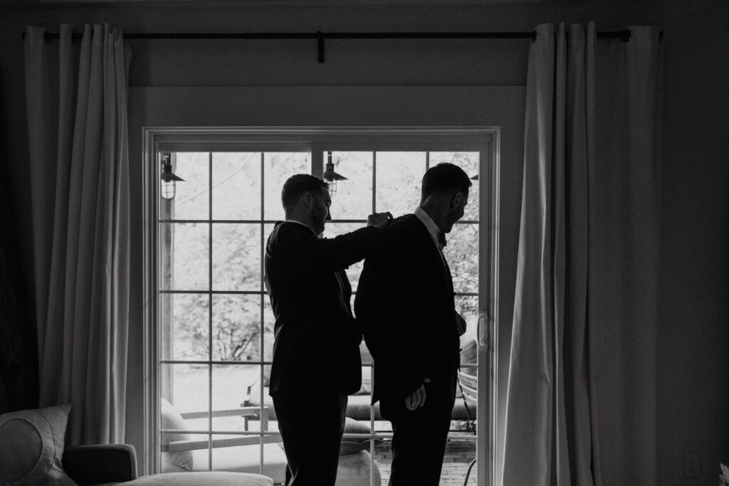best man helps groom get ready for the wedding day